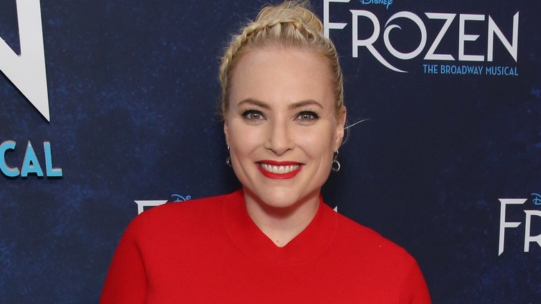 Meghan McCain poses with a smile while wearing red.