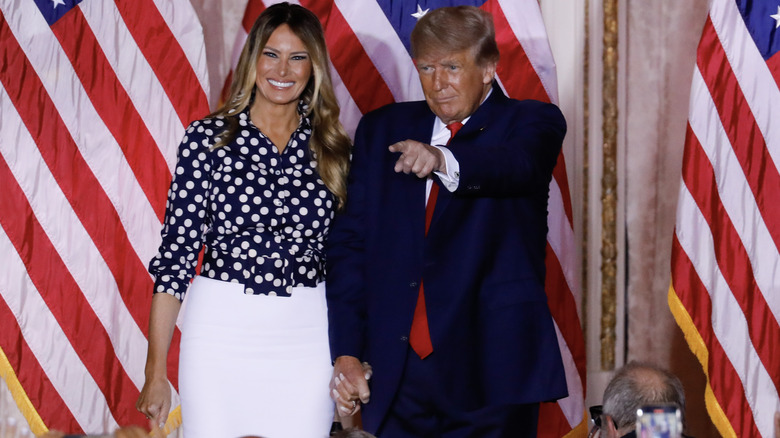 Melania Trump smiling and Donald Trump pointing 