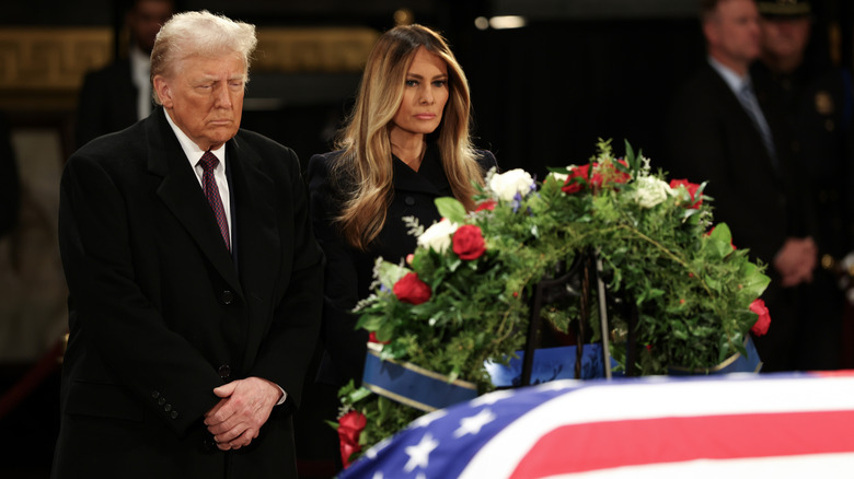 Donald Trump and Melania Trump frowning at Jimmy Carter's funeral