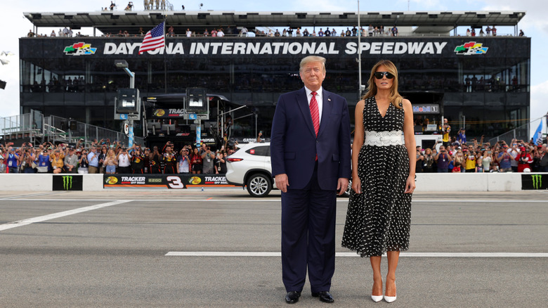 Melania and Donald Trump posing at the NASCAR Cup series