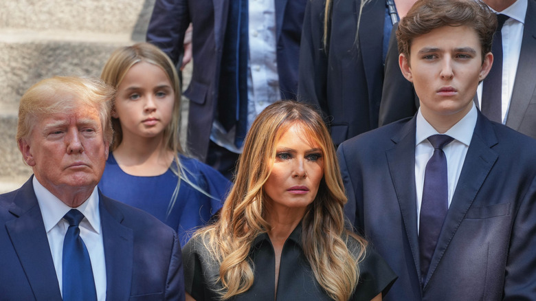 Donald Trump, Melania Trump, and Barron Trump standing next to each other