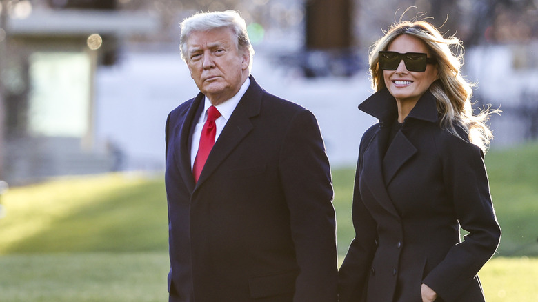 Donald Trump and Melania Trump hold hands while out walking