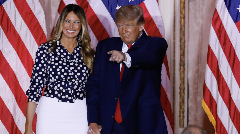 Melania Trump smiling Donald Trump pointing