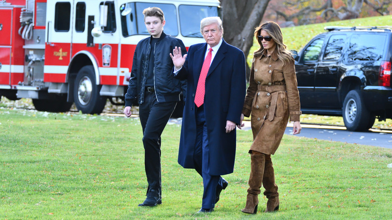 Barron Trump, Donald Trump, and Melania Trump walking on the White House lawn in 2019