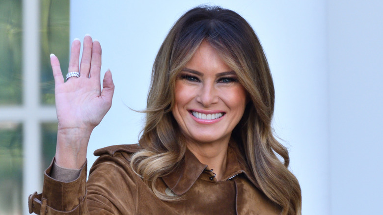 Melania Trump waves and smiles at a crowd.