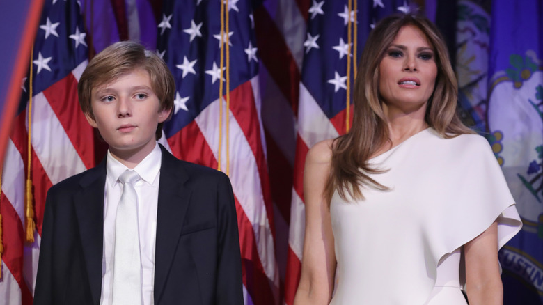 arron Trump and his mother Melania Trump stand on stage