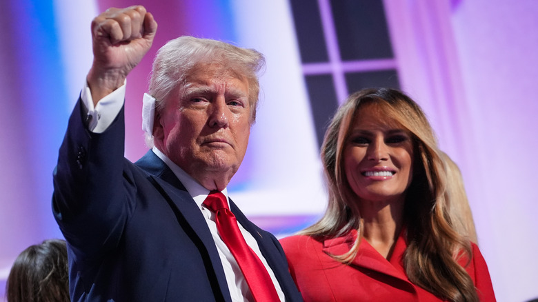 Donald Trump bandaged ear raising fist with Melania in red suit RNC