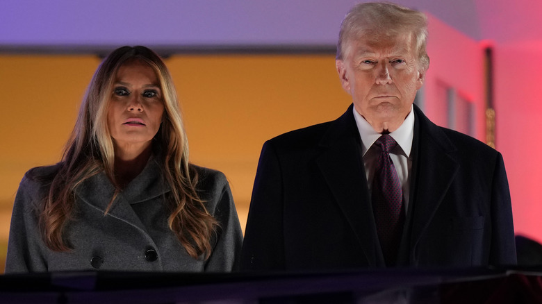 Melania and Donald Trump standing looking solemn fireworks show