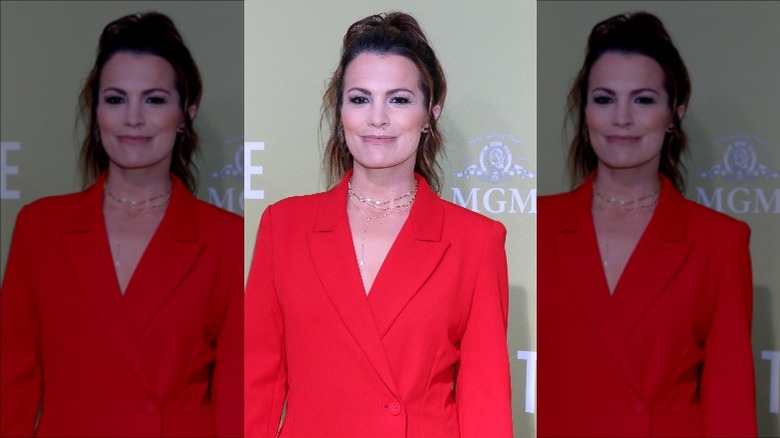 Melissa Claire Egan smiling in red blazer at The Hustle premiere