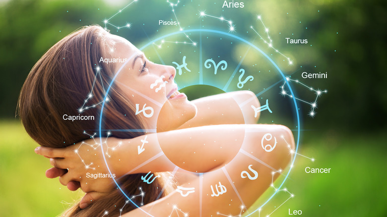 Woman looking up with graphic of zodiac signs superimposed on her