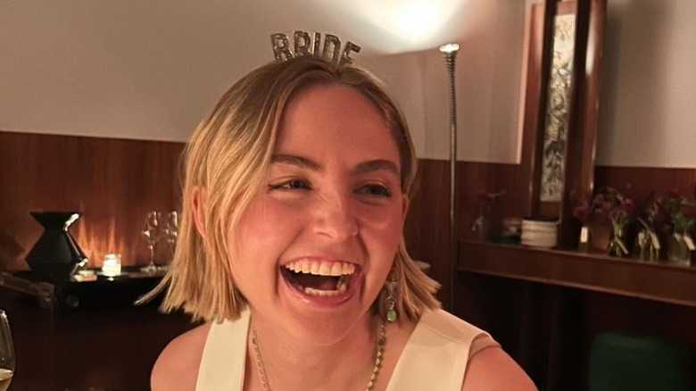 Schuyler Fox laughing at dinner wearing a "bride" headband