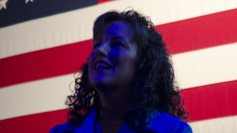 Michelle Duggar speaking in front of flag