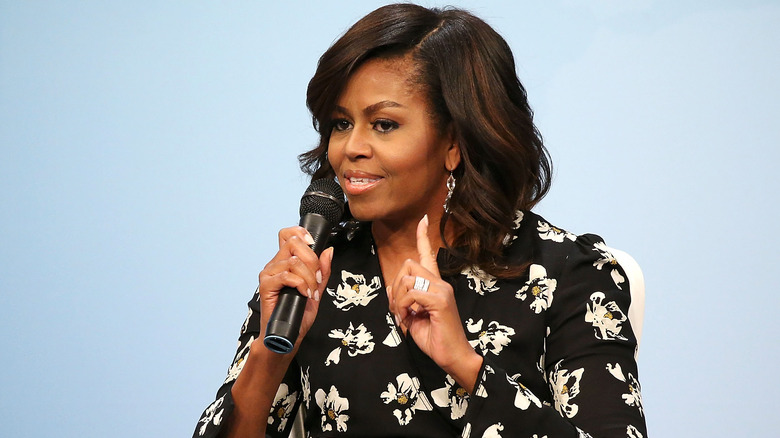 Michelle Obama talking and holding up one finger