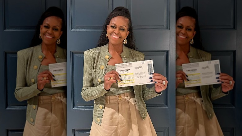 Michelle Obama smiling holding ballot