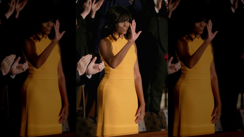 Michelle Obama waves to members of congress before US President Barack Obama delivers the State of the Union speech before members of Congress in the House chamber of the U.S. Capitol in Washington, DC (2016)