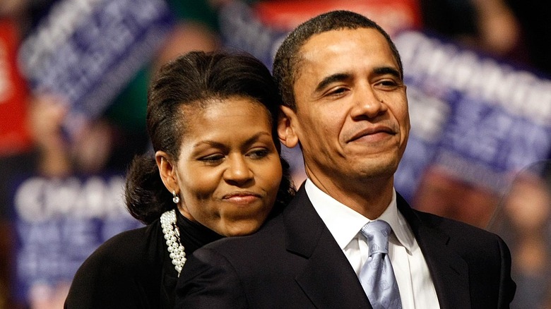 Michelle Obama embracing Barack Obama from behind