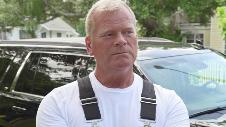 Mike Holmes standing in his overalls