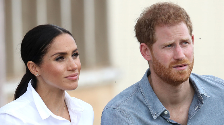 Meghan Markle and Prince Harry listen during an interview