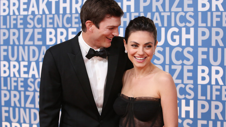 Mila Kunis and Ashton Kutcher pose on the red carpet