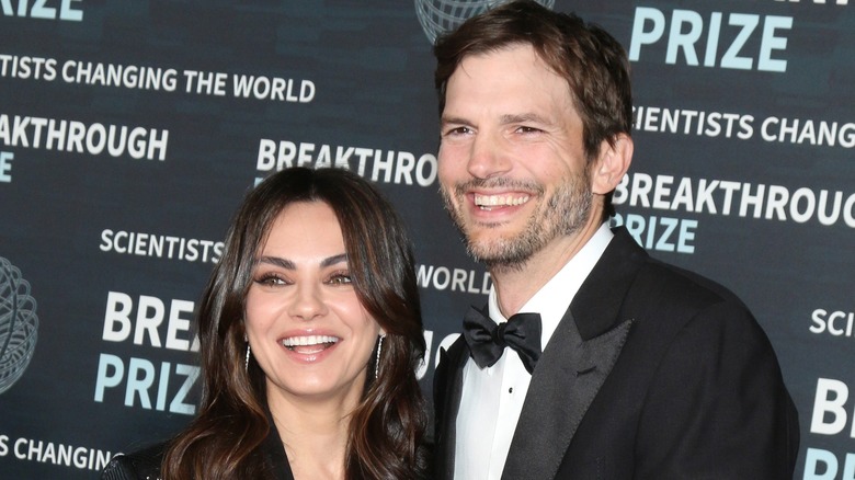 Ashton Kutcher posing with Mila Kunis