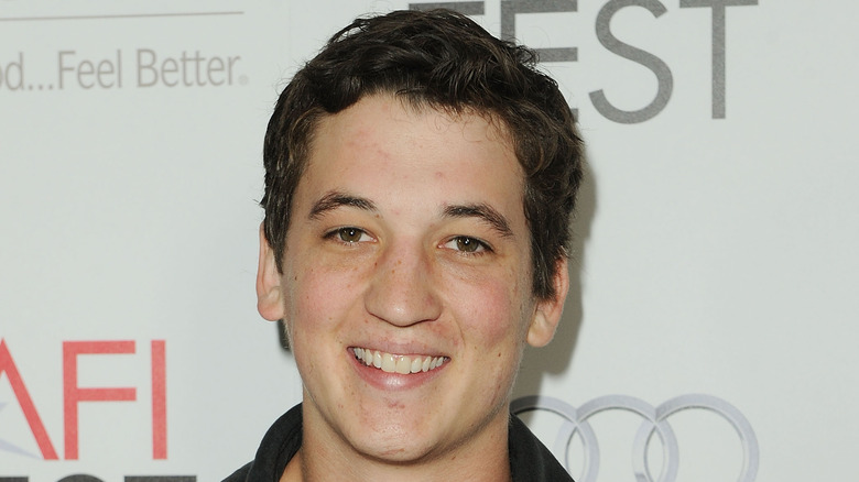 Young Miles Teller in olive tshirt