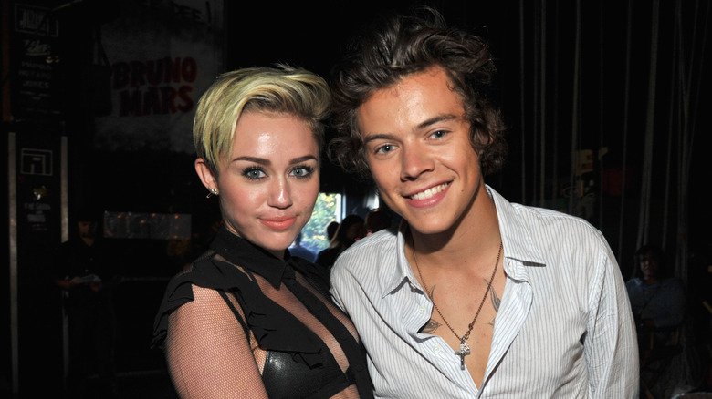 Miley Cyrus and Harry Styles posing backstage