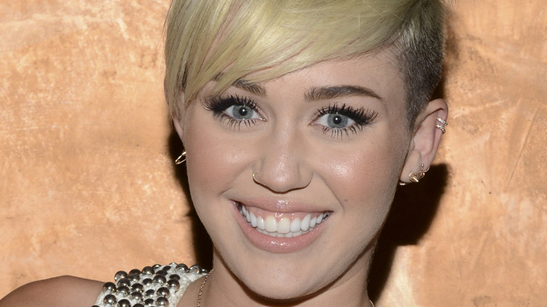 Miley Cyrus with a blonde pixie cut smiling