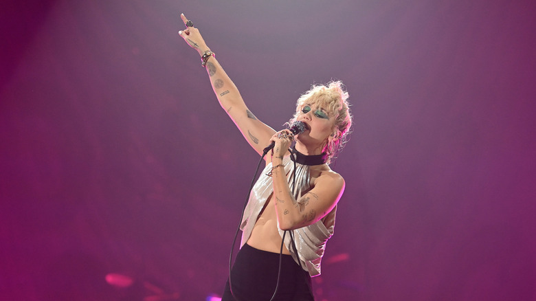 Miley Cyrus pointing while performing onstage in 2021