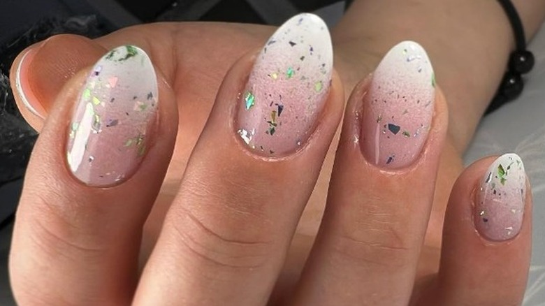 Rounded white nails with green glitter