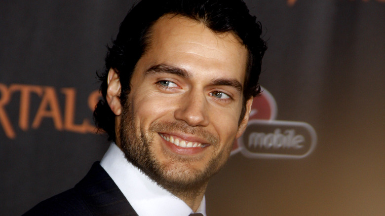 Henry Cavill smiling and looking to the side on the red carpet 