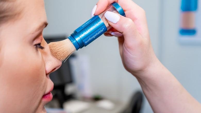 Woman applying powder SPF