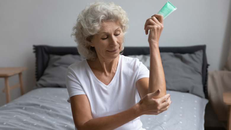 Woman moisturizing her elbows