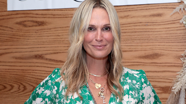 Molly Sims smiling in green and white dress