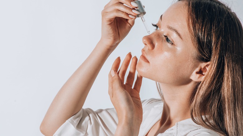 woman applying facial oil 