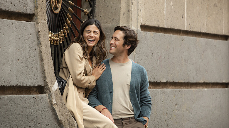 Monica Barbaro as Sophie and Diego Boneta as Alejandro sharing a laugh in AT MIDNIGHT