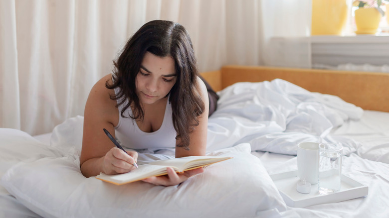 woman journaling in bed