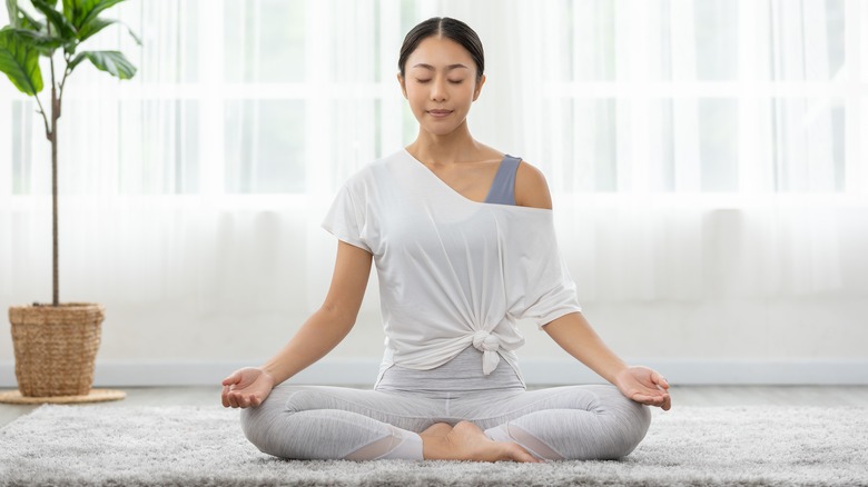 Woman meditates on floor