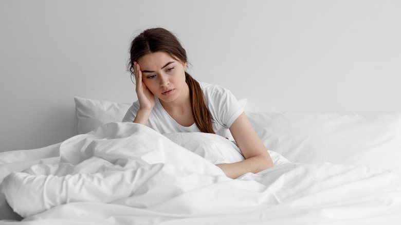 Woman in bed looking anxious