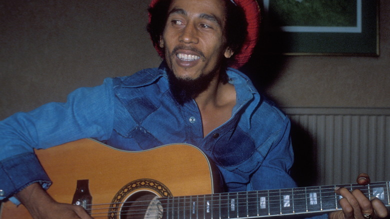 Bob Marley with guitar wearing denims