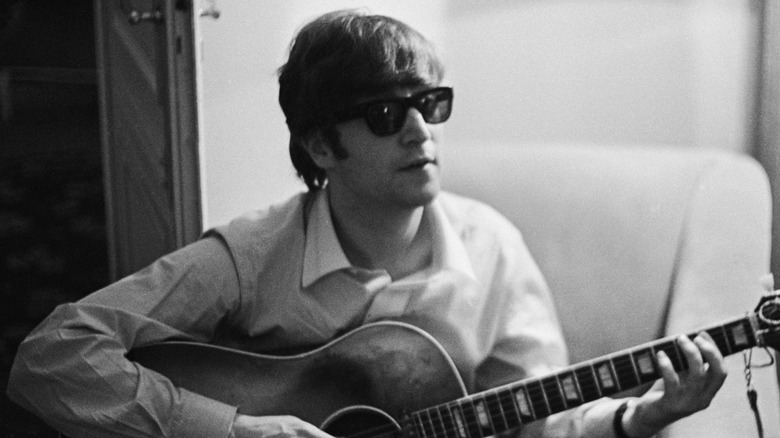 John Lennon with guitar wearing shades and shirt