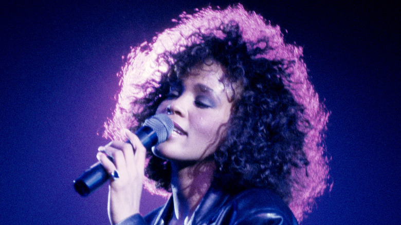Whitney Houston singing with pink halo around hair