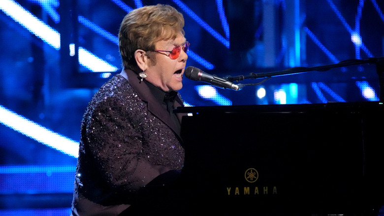 Elton John singing and playing piano