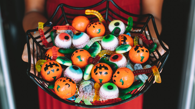 Woman holding bowl with Halloween candy