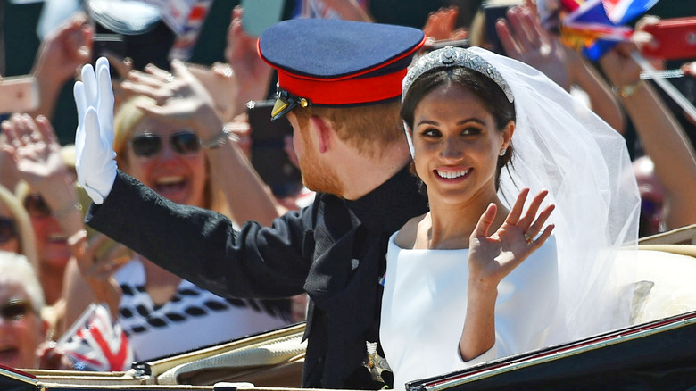 Meghan Markle and Prince Harry waving from their wedding carriage