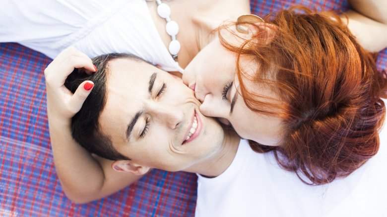 Redheaded woman kissing a man