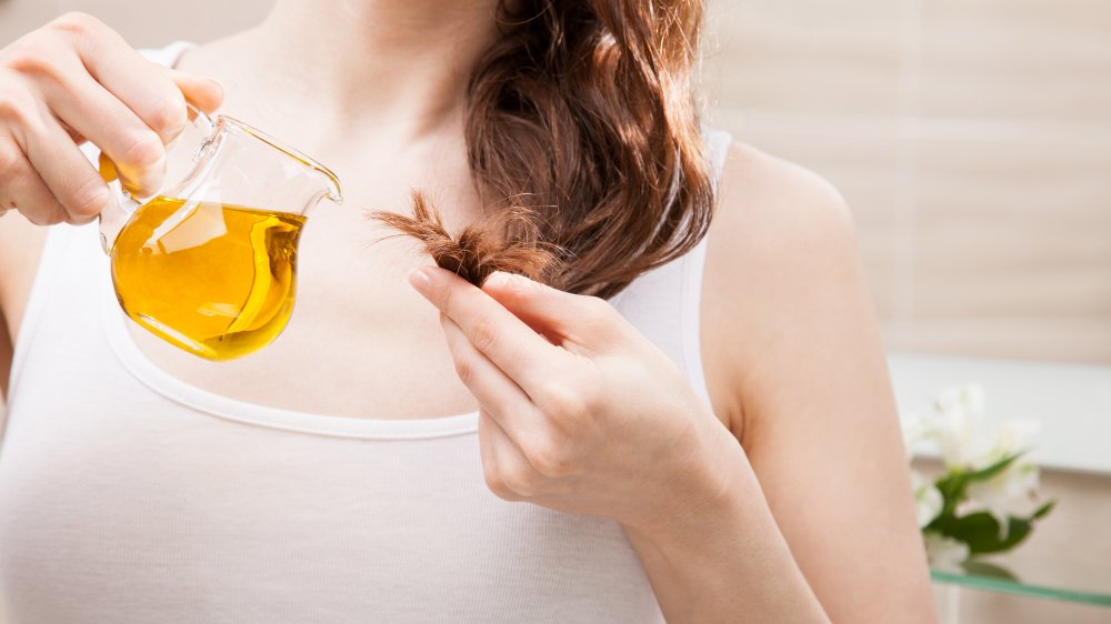 Woman treating split ends with oil 