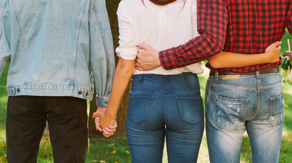 Multiple people in bed, depicting polyamorous relationships