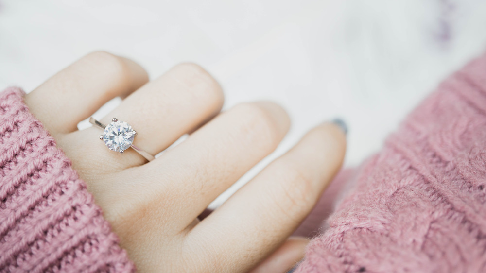 A woman's hand with a diamond ring on her finger