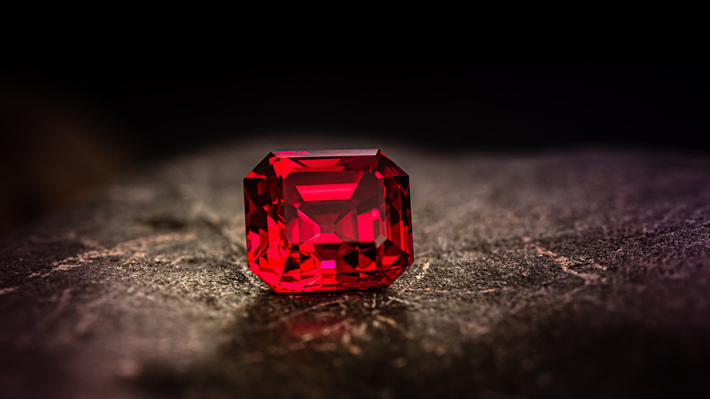 A red gemstone on a brown surface