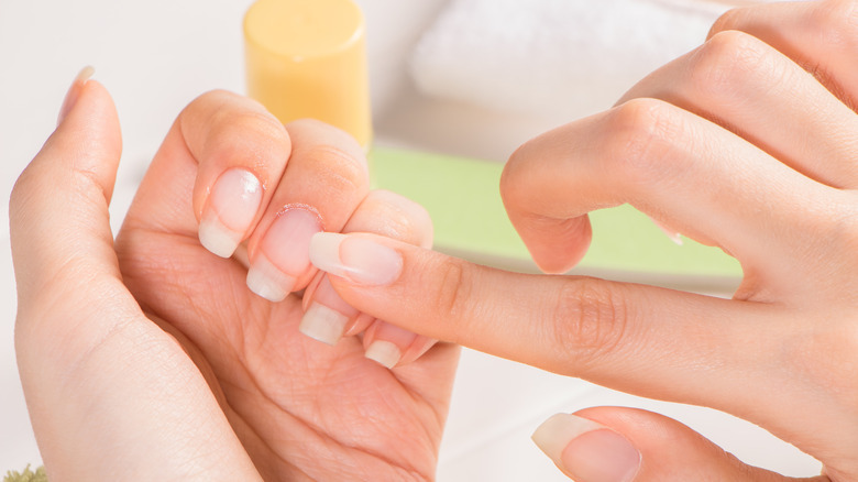 Woman massaging nail cuticle